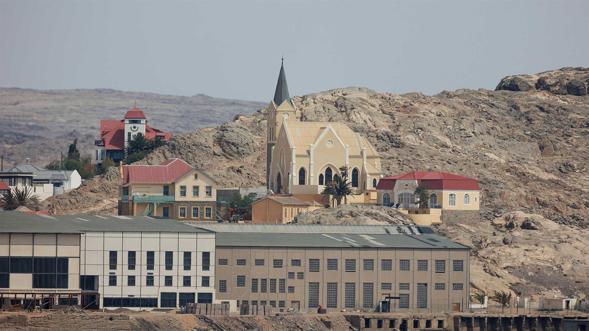 Scenic view of charming colonial-style architecture in arid desert village with prominent church and rugged landscape