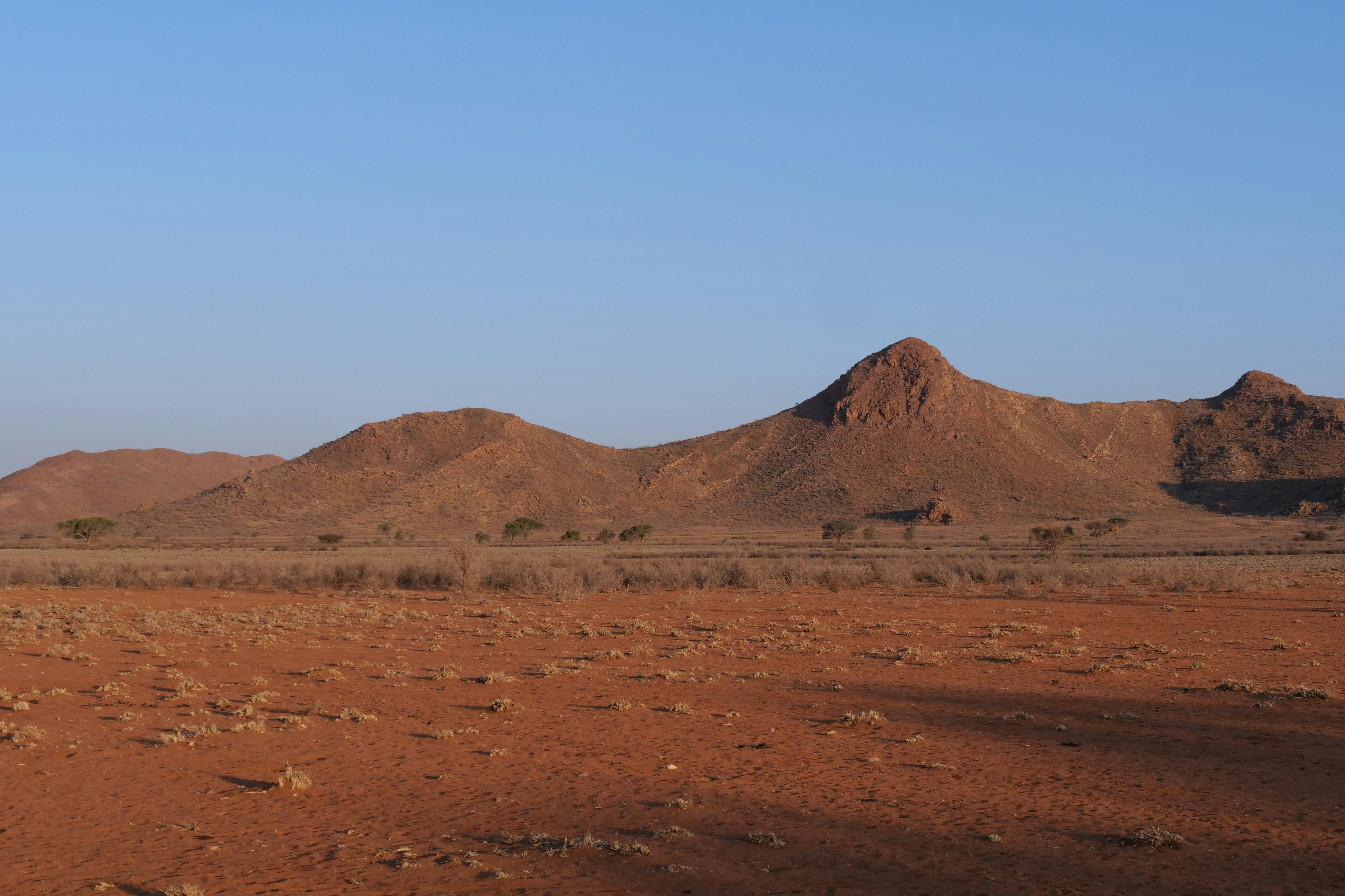 Breathtaking view of a barren desert landscape with rugged hills under a clear blue sky