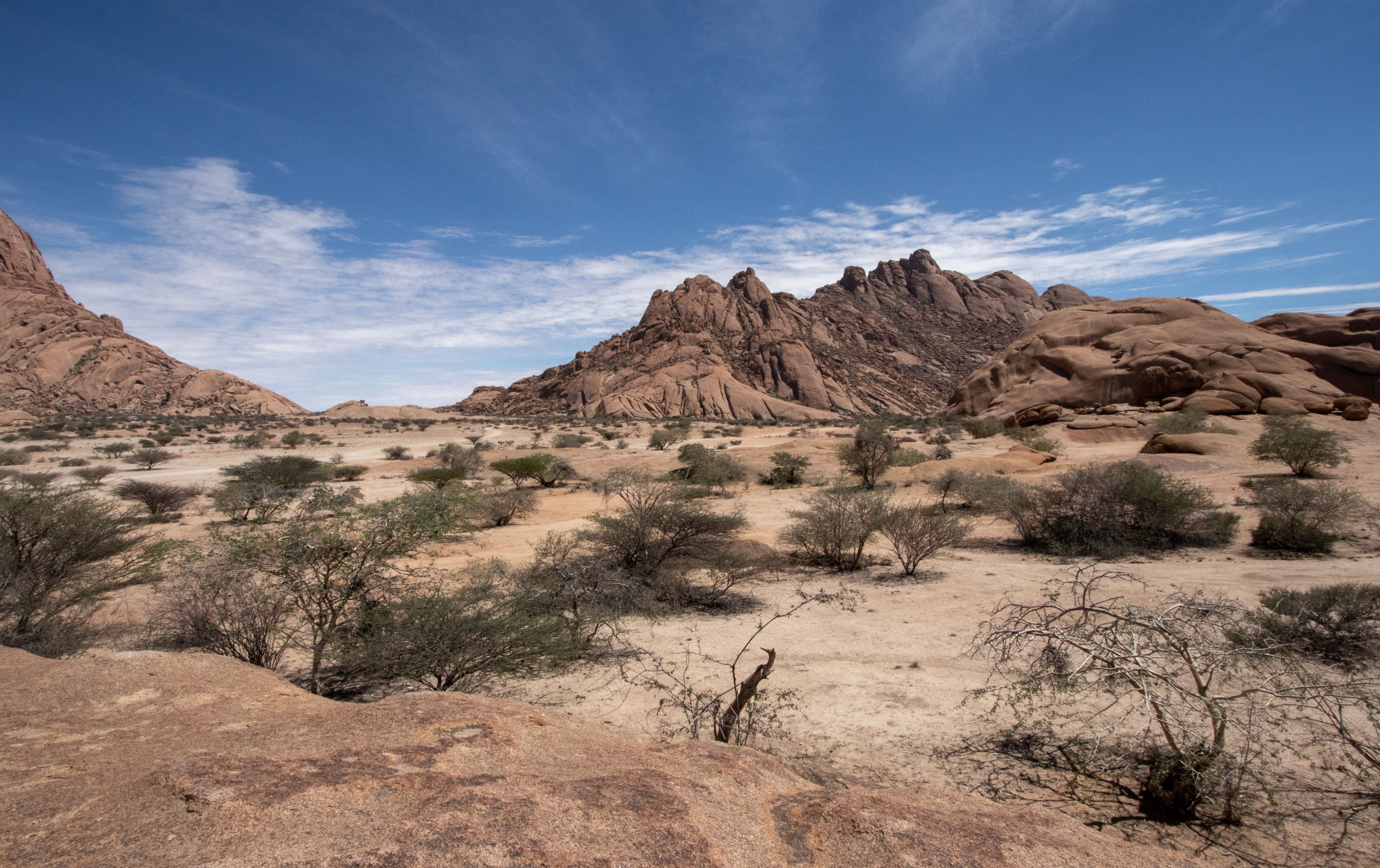 A breathtaking view of a desert landscape featuring rocky mountains under a clear blue sky