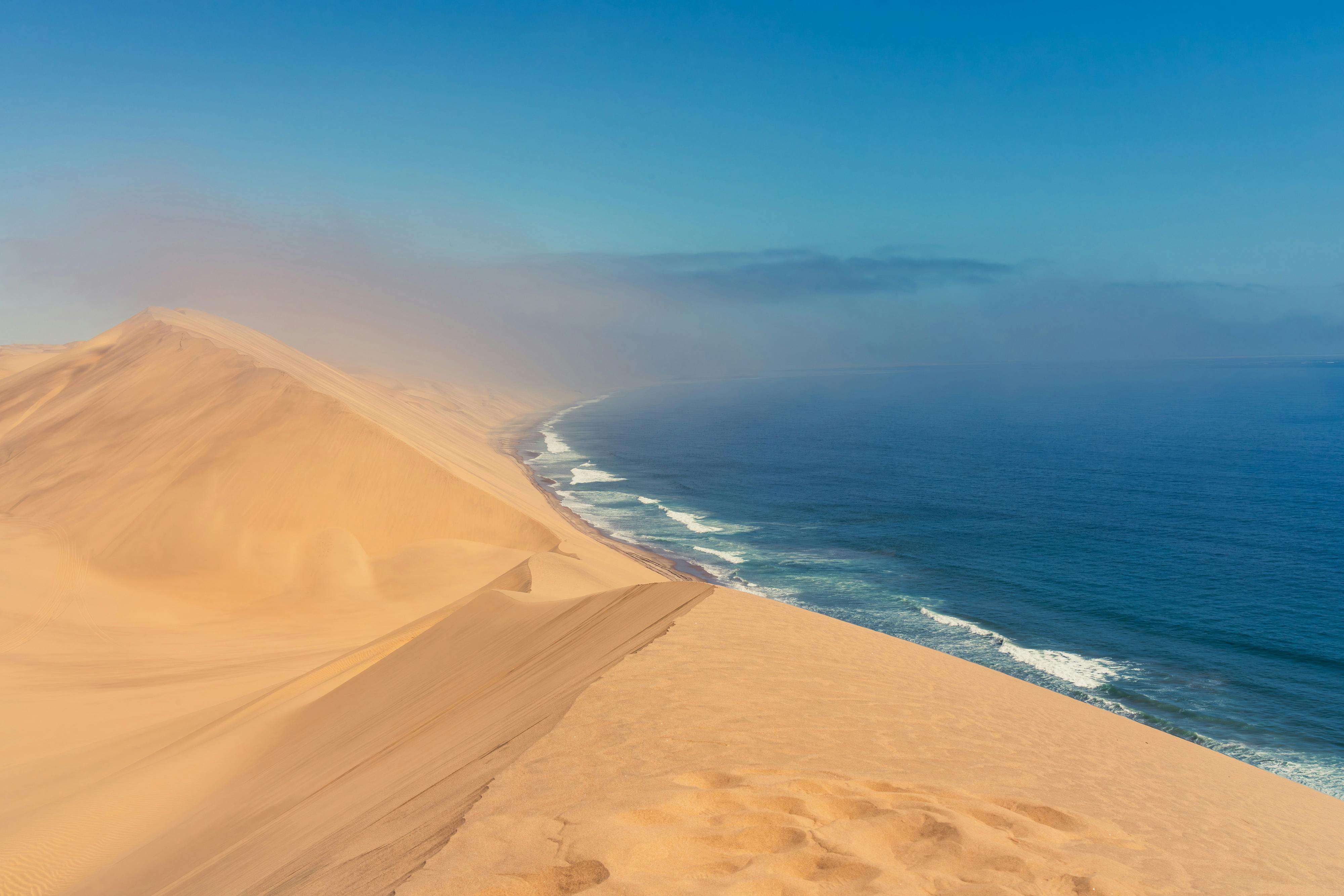 Breathtaking aerial view of desert dunes meeting the coastline