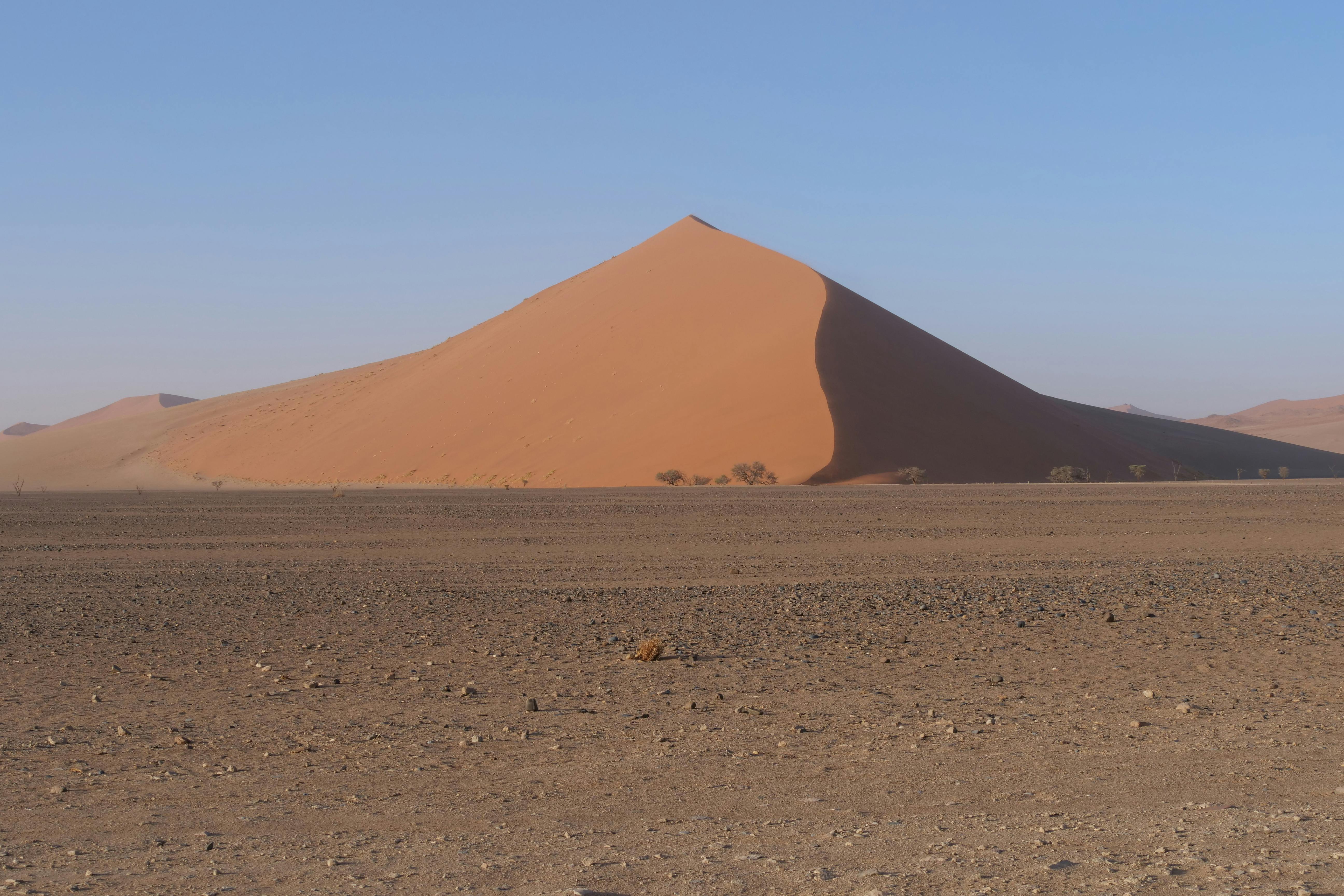 A stunning view of a sand dune in the Namib Desert under a clear sky