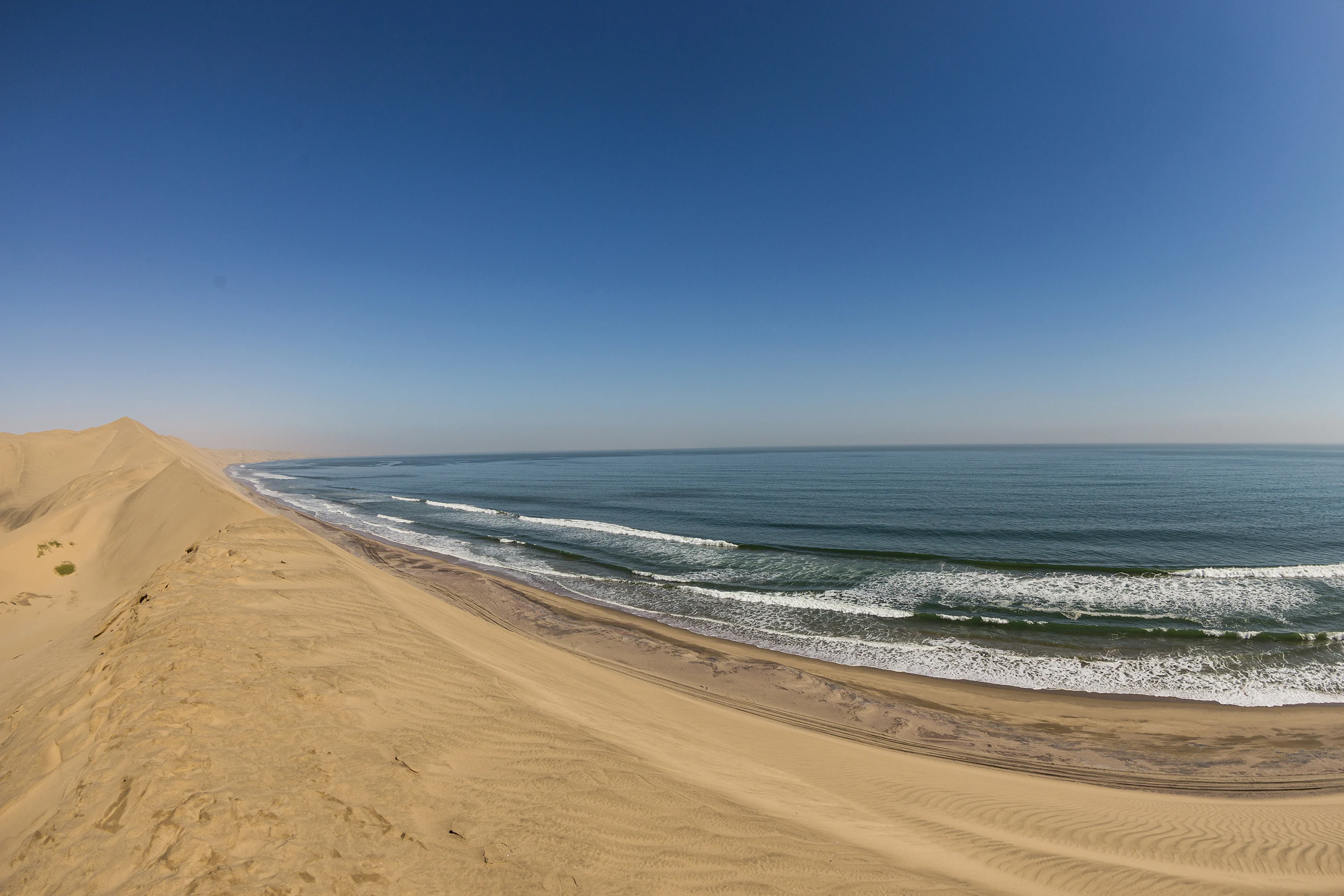Sandwich Harbour - Panoramic view of Namib Desert sand dunes meeting the Atlantic Ocean