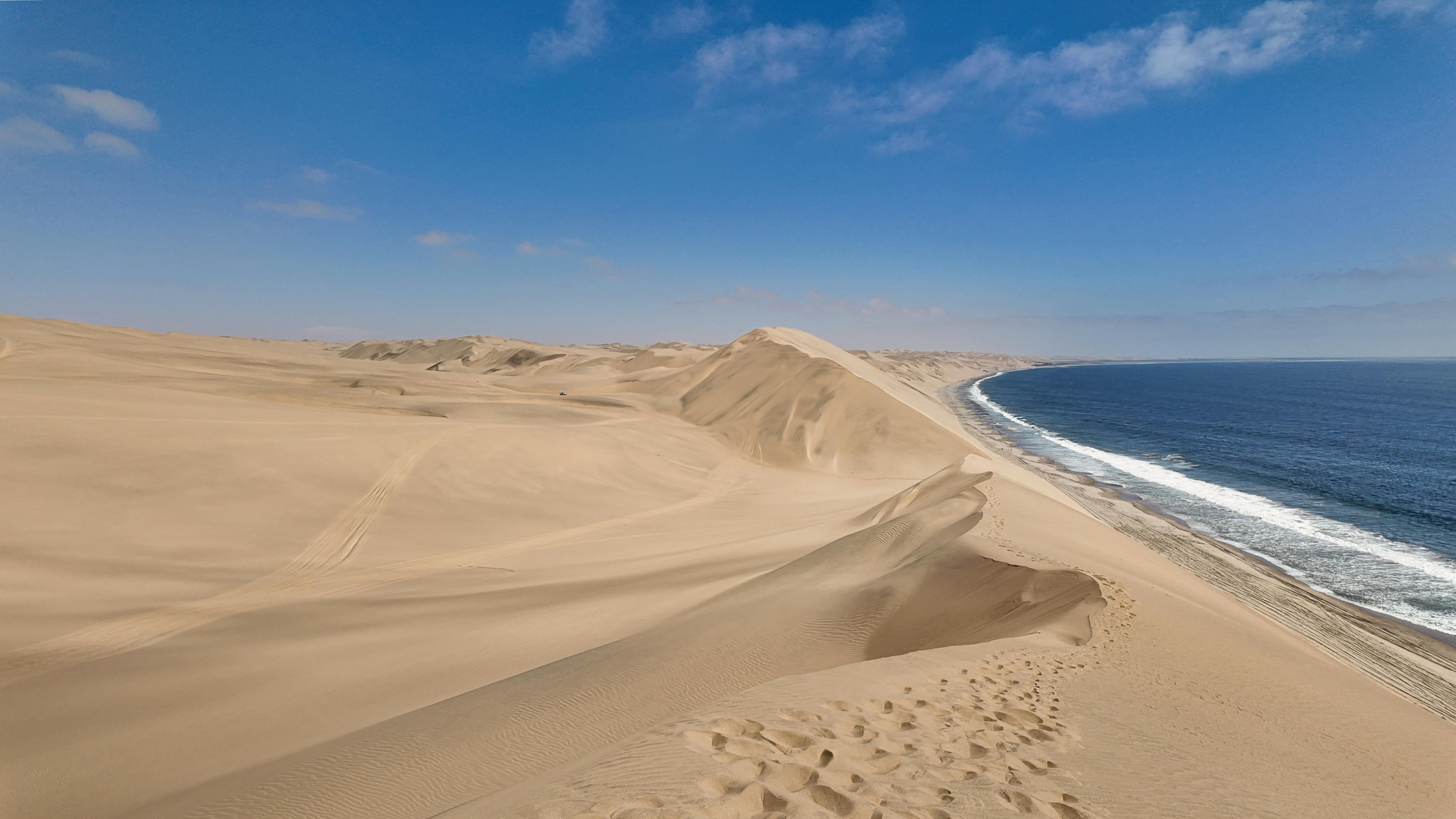 Panoramic view of Namibia sand dunes merging with the Atlantic coastline